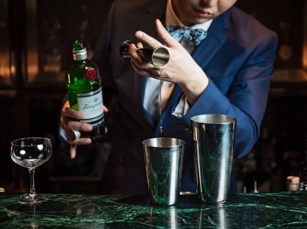 Barkeeper h&auml;lt Gin-Flasche in der Hand